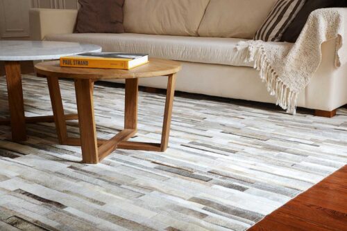 Gray, beige and white patchwork leather area rug in Stripes in a calm living room