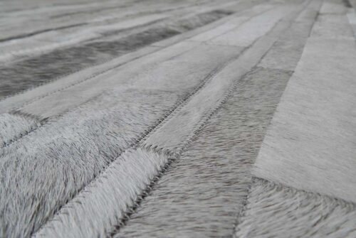 Close up of a gray and white patchwork cowhide rug