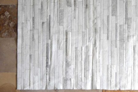 Top view of a gray and white patchwork cowhide rug Top view of a gray and white patchwork cowhide rug