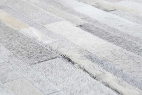 Hair on hide detail of gray and white patchwork cowhide rug in stripes Hair on hide detail of gray and white patchwork cowhide rug in stripes
