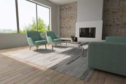 Gray and white patchwork cowhide rug in strips with aqua furniture in a bright living room