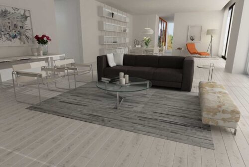 Gray and white area cowhide rug in stripes in an open living room