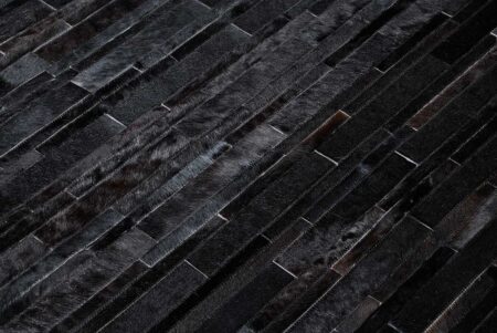 Detail of a Black Patchwork Cowhide Rug Design in stripes Detail of a Black Patchwork Cowhide Rug Design in stripes