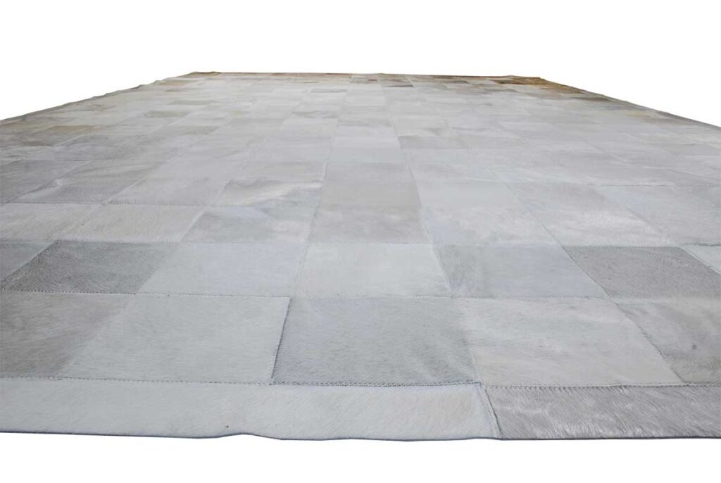 White cowhide patchwork rug in squares with border