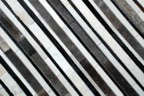 Top detail of White, gray and black leather area rug in stripes