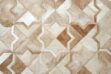 Top view of a beige natural cowhide patchwork rug in the Moorish Star design