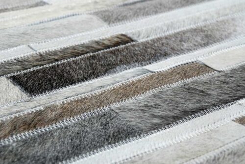Hair detail of a taupe gray cowhide patchwork rug in Stripes