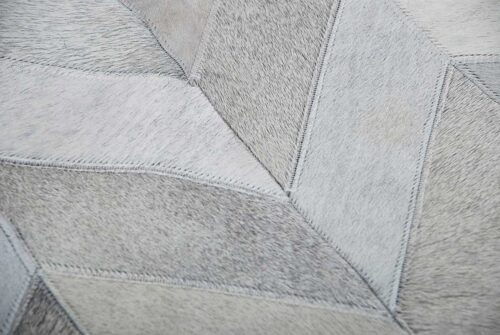 Detail of a gray cowhide patchwork rug in a chevron design