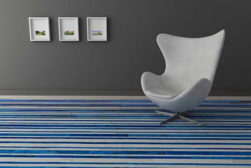 Blue and white cowhide patchwork rug in striped design with modern Egg chair