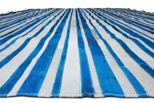 Floor view of Blue and white cowhide patchwork rug in striped design