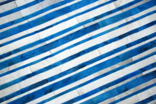 Detail of Blue and white cowhide patchwork rug in stripes design