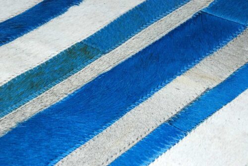 Close up of Blue and white cowhide patchwork rug in stripes design
