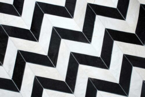 Top close up of black and white chevron patchwork cow hide rug