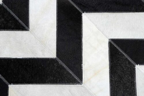 Hair on hide detail of black and white chevron patchwork cowhide rug