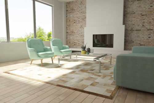 Beige and white patchwork cowhide rug in bricks design with border in sunny living room