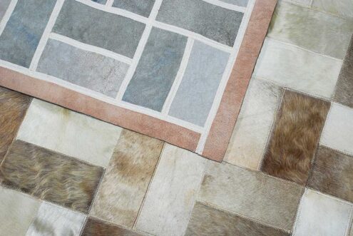 Beige and white patchwork cowhide rug in bricks design with border and backing Beige and white patchwork cowhide rug in bricks design with border and backing