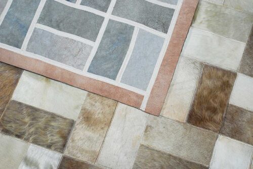 Beige and white patchwork cowhide rug in bricks design with border and backing