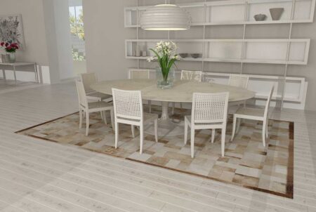 Beige and white patchwork cowhide rug in bricks design with border in dining room Beige and white patchwork cowhide rug in bricks design with border in dining room