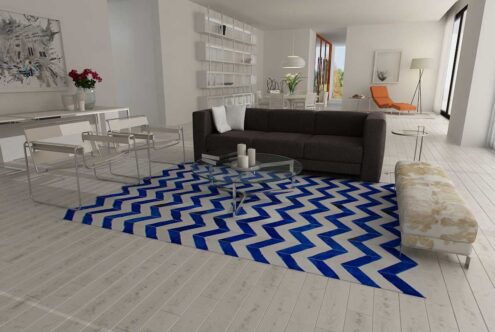 Blue and white cowhide patchwork rug in a chevron design in a minimal living room Blue and white cowhide patchwork rug in a chevron design in a minimal living room