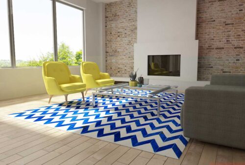 Blue and white cowhide patchwork rug in a chevron design in a sunny living room