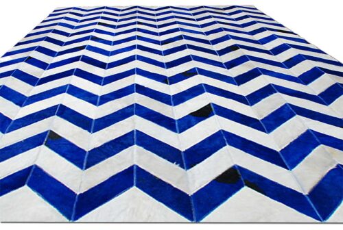 Floor view of a natural a cowhide patchwork rug in blue and white in a chevron design