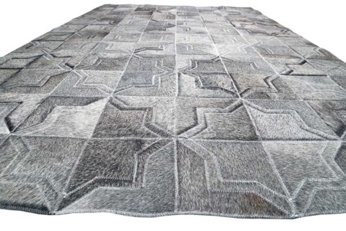 Floor view of a dark gray patchwork cowhide rug in a moorish star design