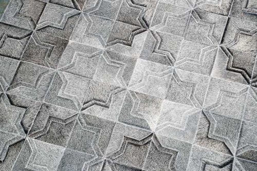 Top view of a Dark gray patchwork cowhide rug in a moorish star design