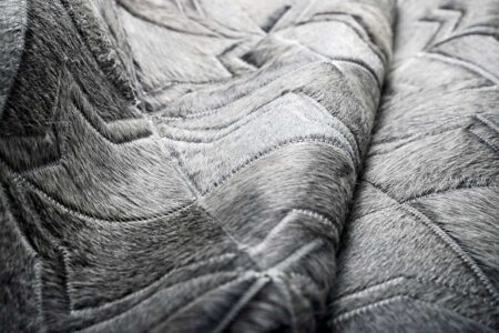 texture detail of a Dark gray patchwork cowhide rug in a moorish star design texture detail of a Dark gray patchwork cowhide rug in a moorish star design