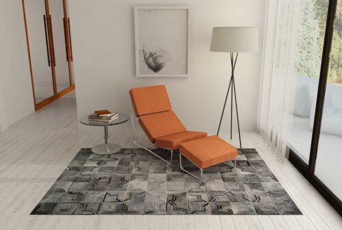 Dark gray patchwork cowhide rug in a moorish star design in a minimal reading nook