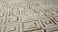 Close up of white and beige cowhide patchwork rug in diamond design