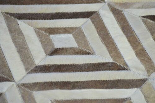 Hair on hide detail of white and beige leather area rug in diamond design