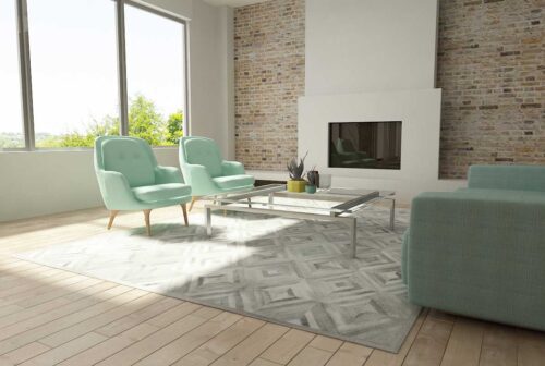Diamond gray cowhide patchwork rug in a sunny living room with aqua furniture