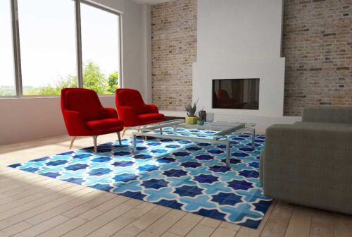 Moorish Star Blue and White Patchwork Cowhide Area Rug in a sunny living room with bright red armchairs