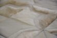 Hair on hide detail of white patchwork cowhide rug in moorish star design