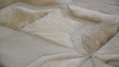 Hair on hide detail of white patchwork cowhide rug in moorish star design