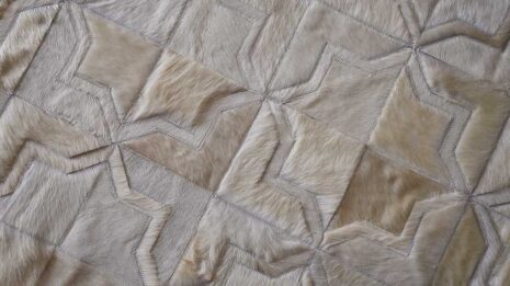 Top view of detail of white patchwork cowhide rug in moorish star design