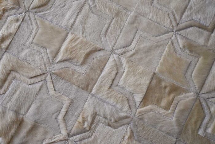Top view of detail of white patchwork cowhide rug in moorish star design