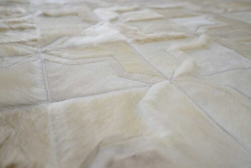 Detail of white patchwork cowhide rug in moorish star design