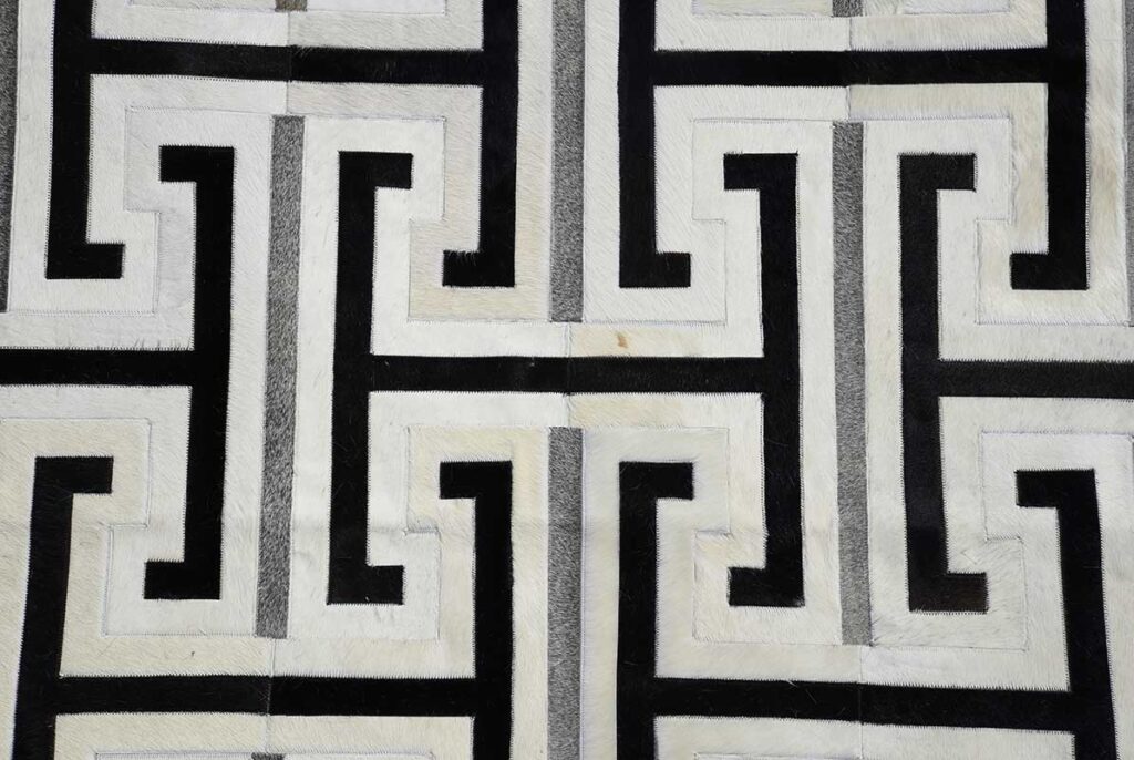 Top detail of Black, gray and white leather area rug design