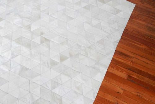 Wooden floor and white cowhide patchwork rug