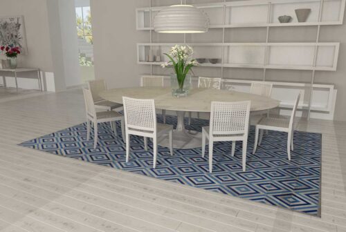 Patchwork Cow Rug in Grey and Blue Diamonds in a bright dining room with a Tulip table