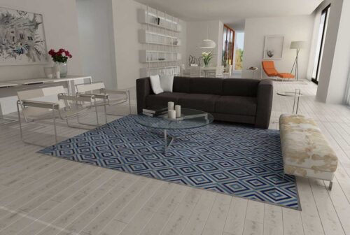 Blue and Gray Diamond Patchwork Cowhide Rug in an open living room with a big dark sofa