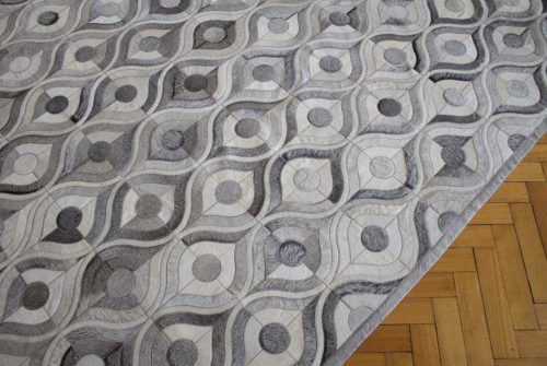 Gray and white cowhide patchwork rug with hair border