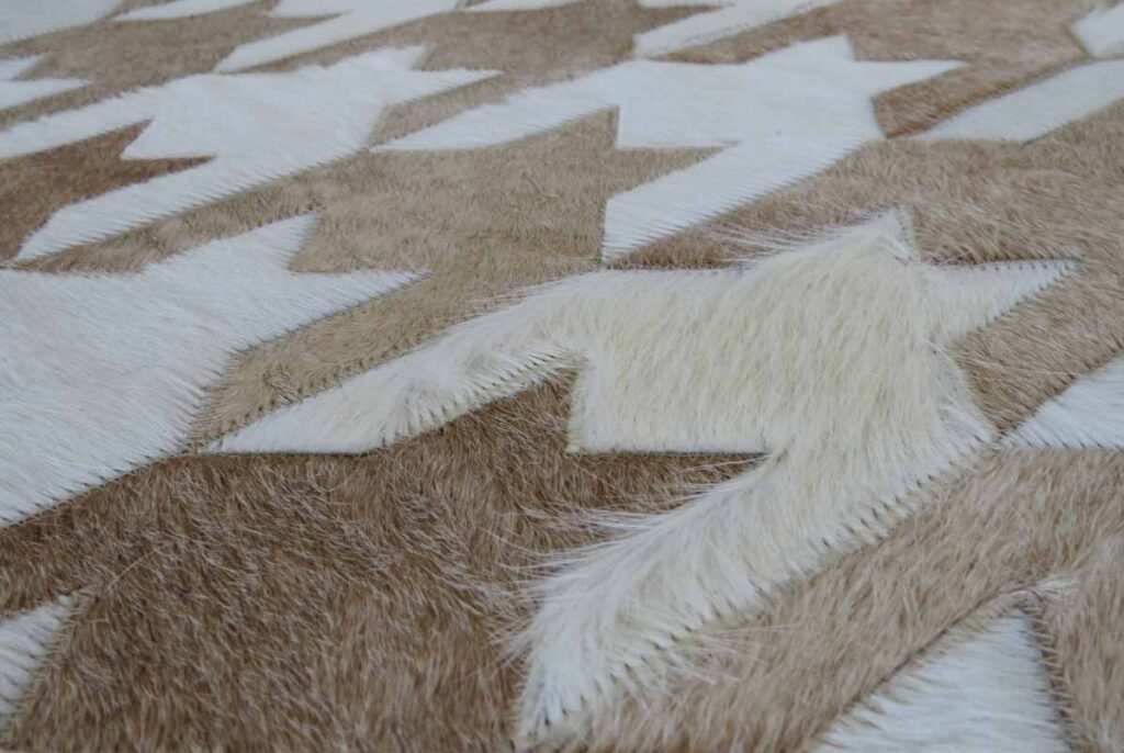 Detail of a HOUNDSTOOTH White and Beige patchwork cowhide rug