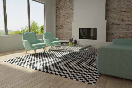 Checkerboard patchwork cowhide rug in a bright living room with teal furniture