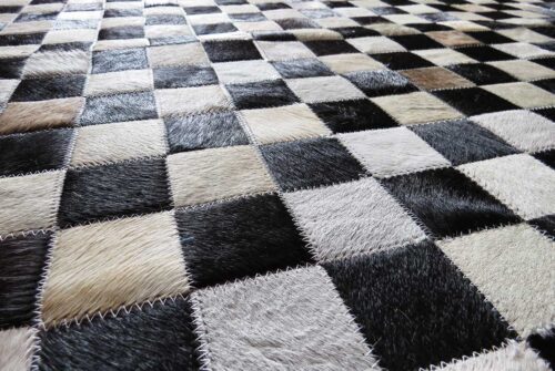 Detail of taupe and black cowhide patchwork rug in squares