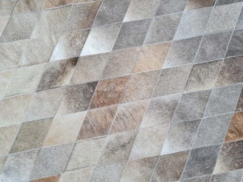 Top view of a LIME taupe and gray patchwork cowhide rug, in trapezoids design pattern