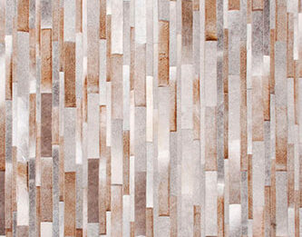 Gray, beige and white patchwork cowhide rug designed in stripes