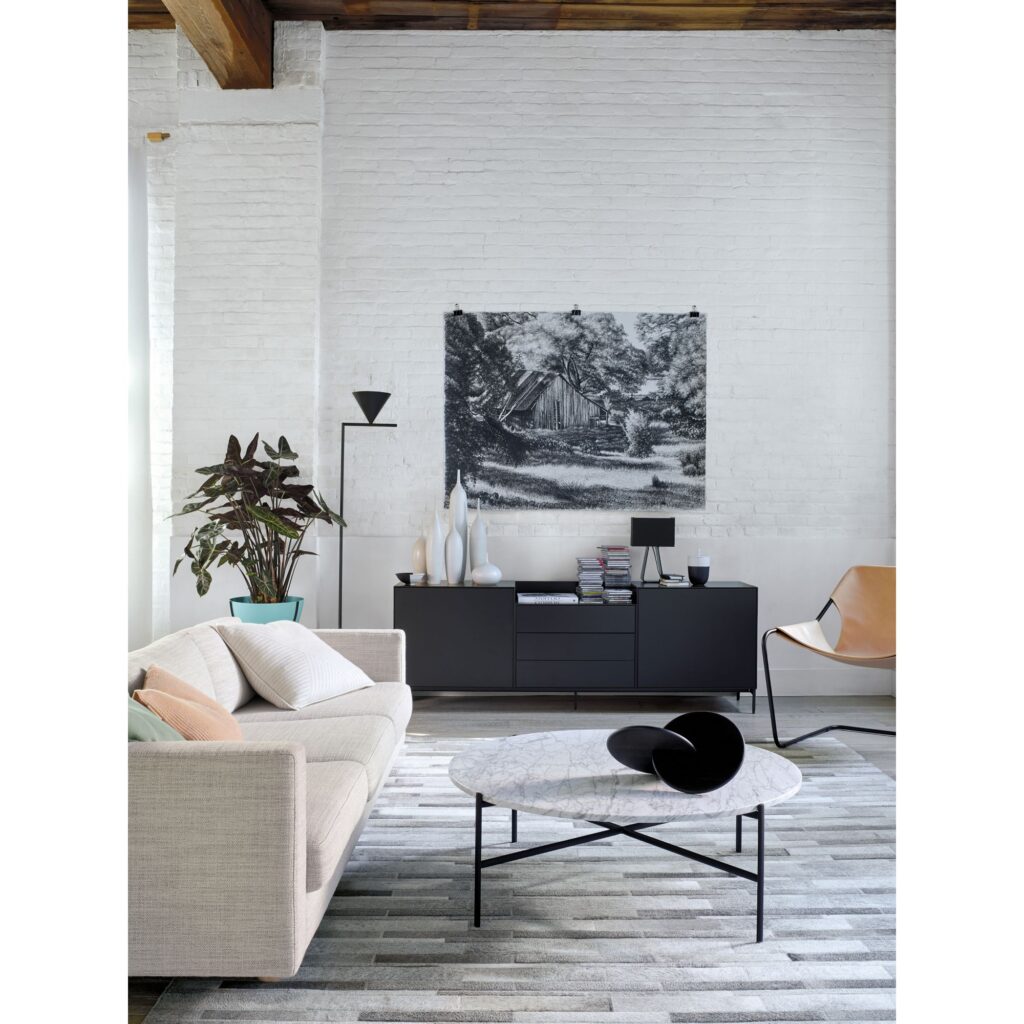 A Stripes Gray and White Patchwork Cowhide Rug adds warmth and coziness to a modern living room