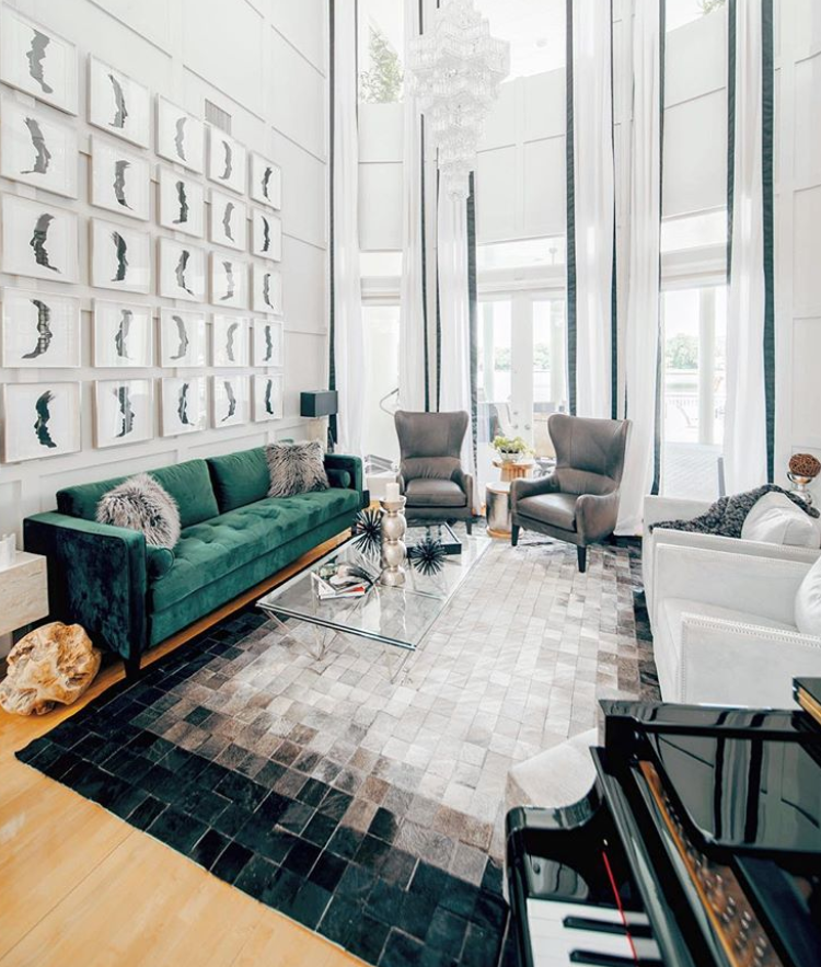 A living room with tall ceilings, lots of natural light, emerald green sofa and a gradient Black, Gray and White SQUARES Patch Cowhide Rug by Shine Rugs